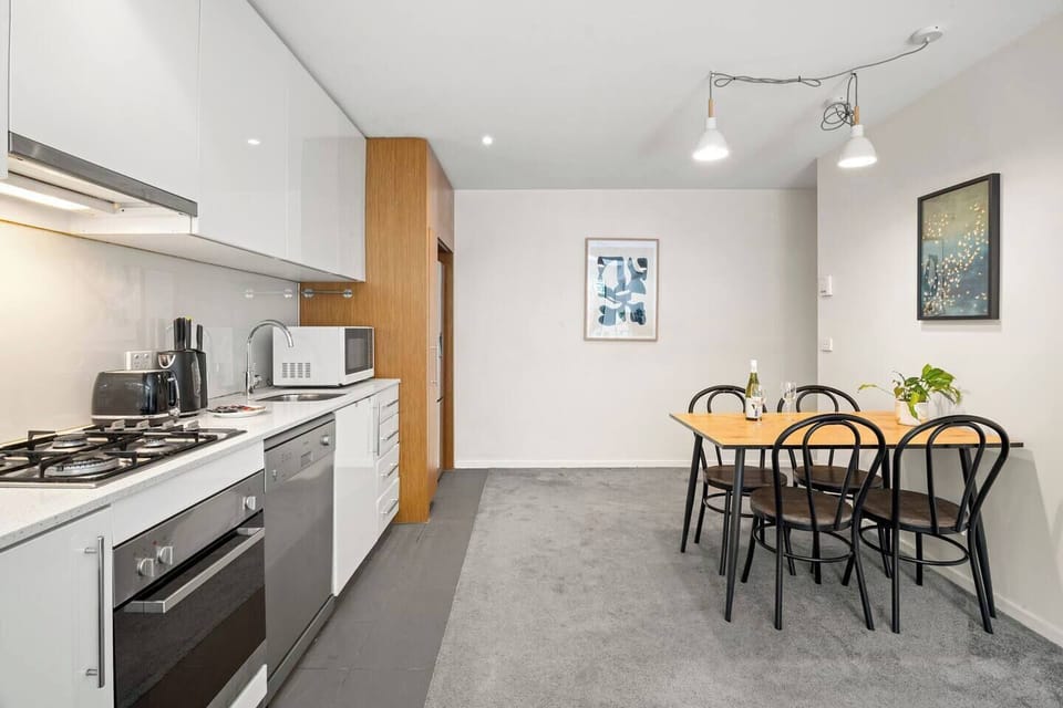 The kitchen offers a complete setup for home-style cooking, featuring sleek modern appliances—gas cooktop, oven and dishwasher—alongside all the essential tools you’ll need for easy meal preparation.