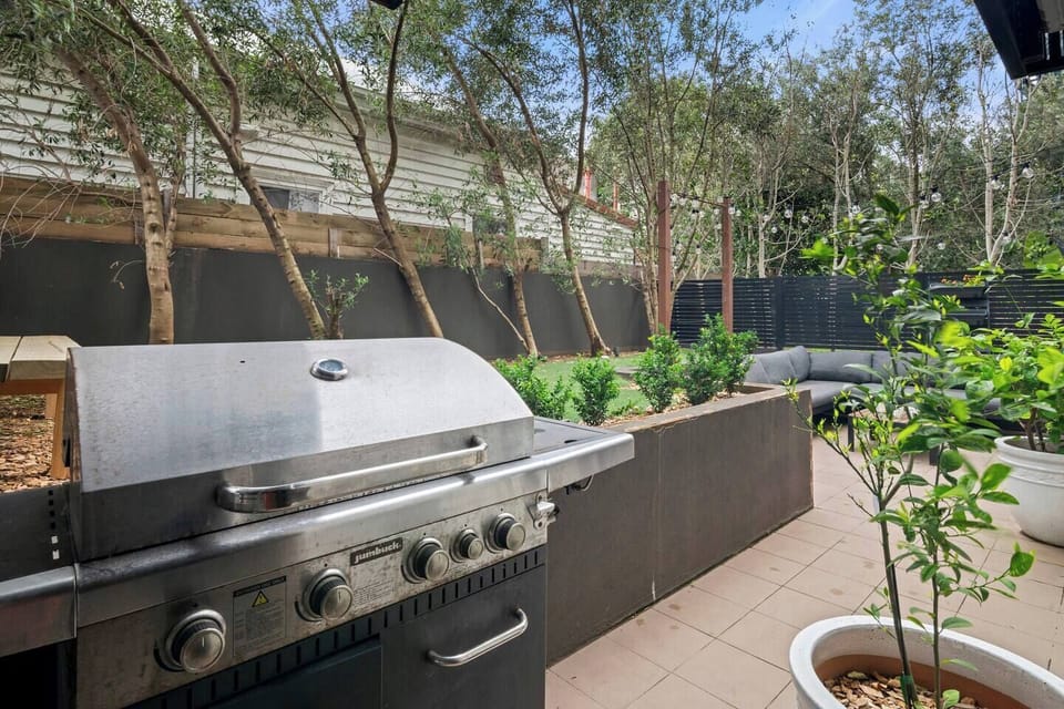 A gas grill and nearby greenery set the stage for easy alfresco cooking and casual meals under the sky.
