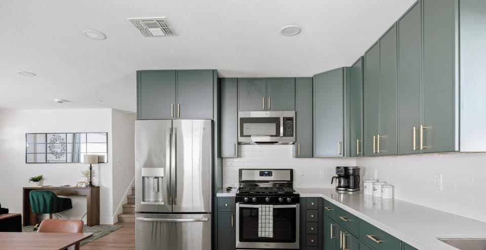 Modern kitchen with stainless appliances and stylish sage cabinetry