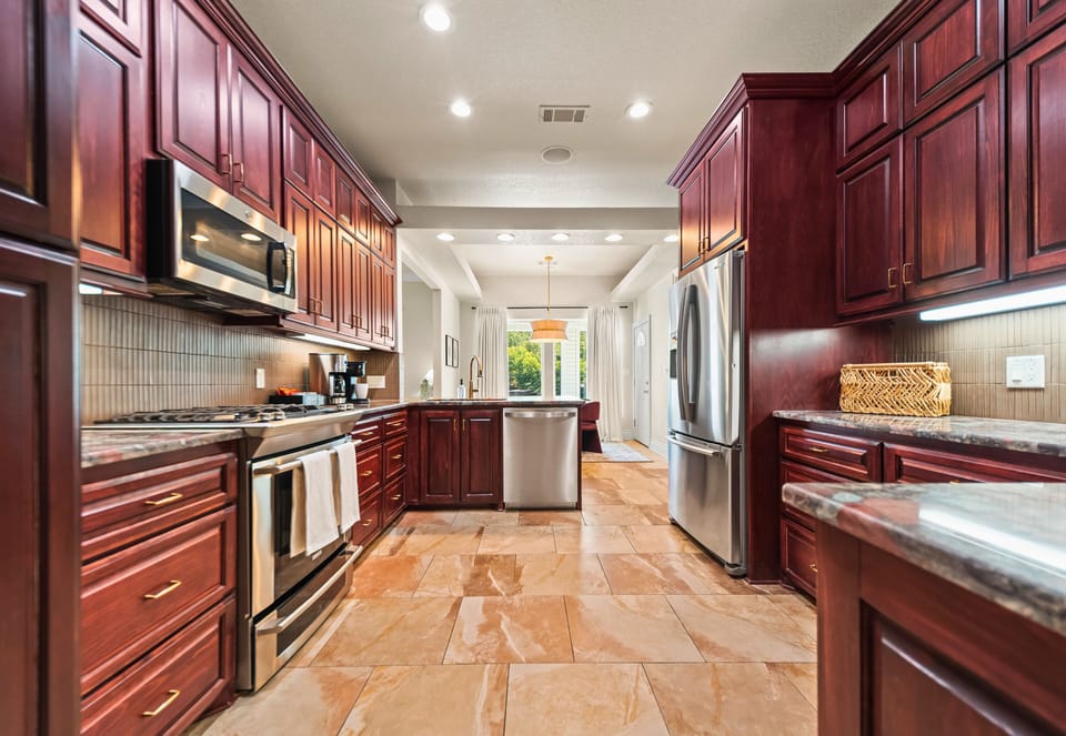 Rich cabinetry, stainless steel appliances, and generous storage make cooking both easy and enjoyable.