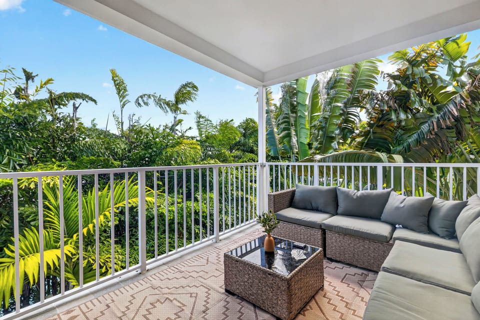A breezy balcony lounge wrapped in lush tropical greenery.