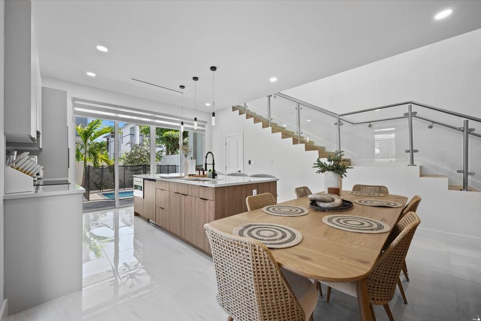 Bright dining area with wooden table and sleek contemporary chairs.