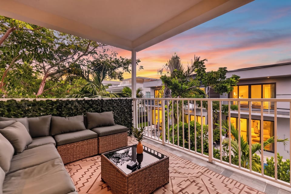 Unwind on the private balcony with comfortable lounge seating and colorful sunset views.