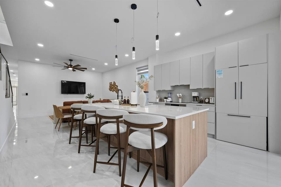 Kitchen island breakfast bar with barstool seating open to living area.