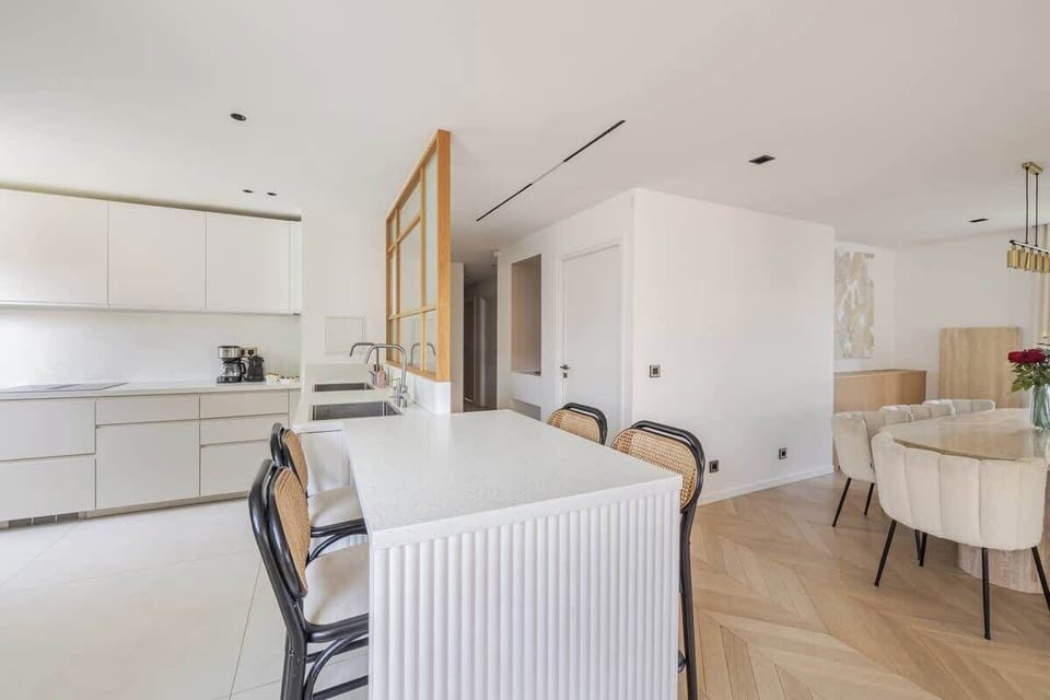 À gauche, la cuisine. À droite, l'espace repas. Appréciez un logement particulièrement spacieux  (200 m²).
