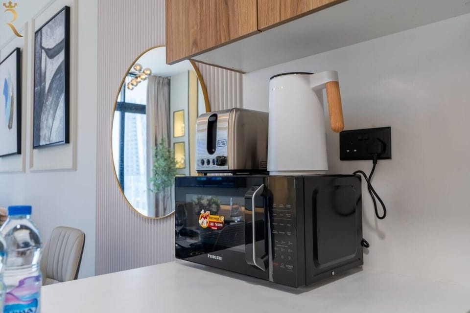 Well-equipped kitchen counter with a microwave, toaster, and electric kettle for quick and easy meal prep.