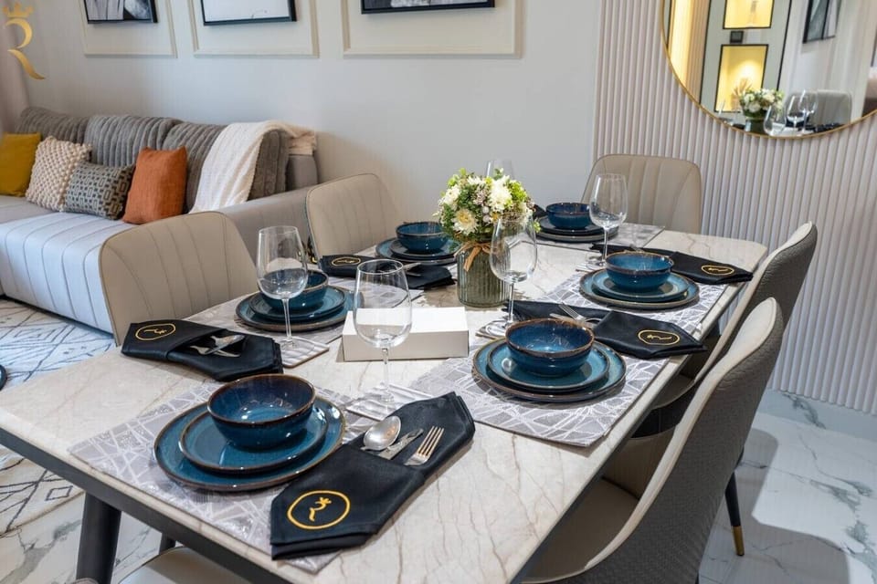 Elegantly set marble dining table with designer tableware and fresh florals, seamlessly connected to the living space.