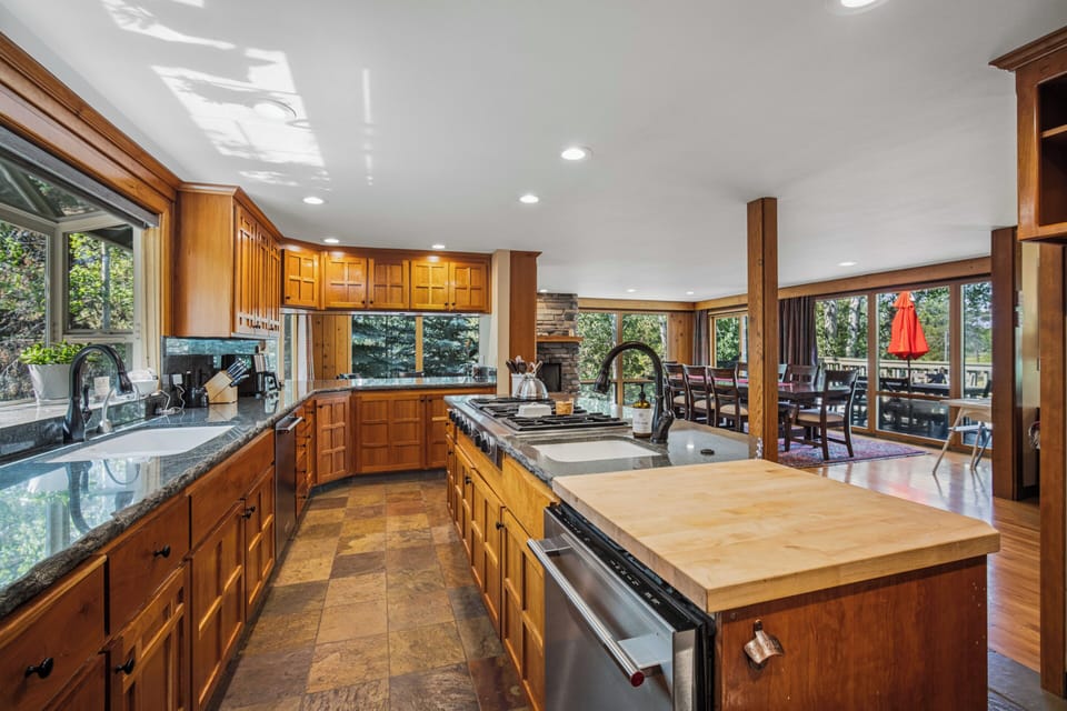 Your gourmet kitchen invites you to gather and cook in style, with rich wood cabinetry, gleaming granite counters, and a spacious island perfect for meal prep or morning coffee.