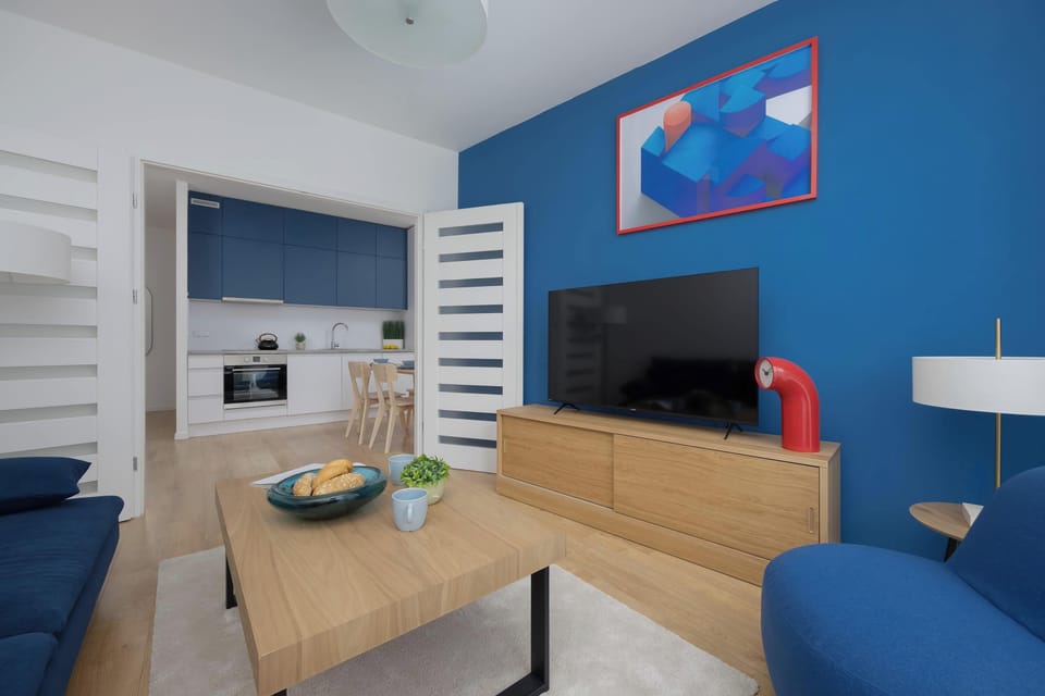 Another angle of the lounge highlights the cozy seating area, decorative wall art, and modern TV unit. Clean lines and bold colors give the room a contemporary feel.