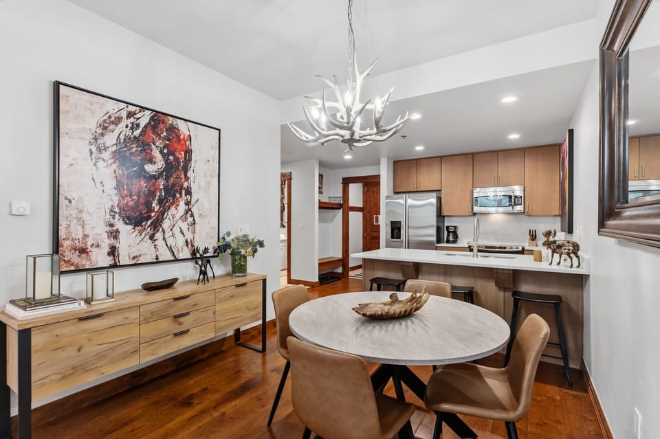 Step into a beautifully designed space where modern elegance meets mountain charm. Your open-concept living and dining area flows seamlessly into a fully equipped kitchen, all bathed in natural light and finished with warm wood accents throughout.