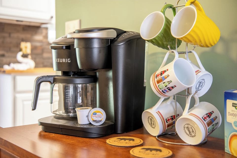 Start your mornings right with your own coffee station, complete with a Keurig brewer and a cheerful mug collection ready for your first cup.
