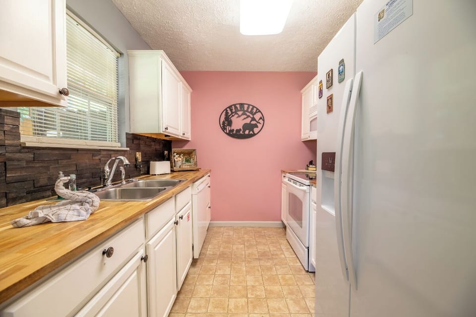 Your fully equipped kitchen features warm wood countertops, bright white cabinetry, and all the essentials for preparing meals during your stay, making it easy to feel right at home.