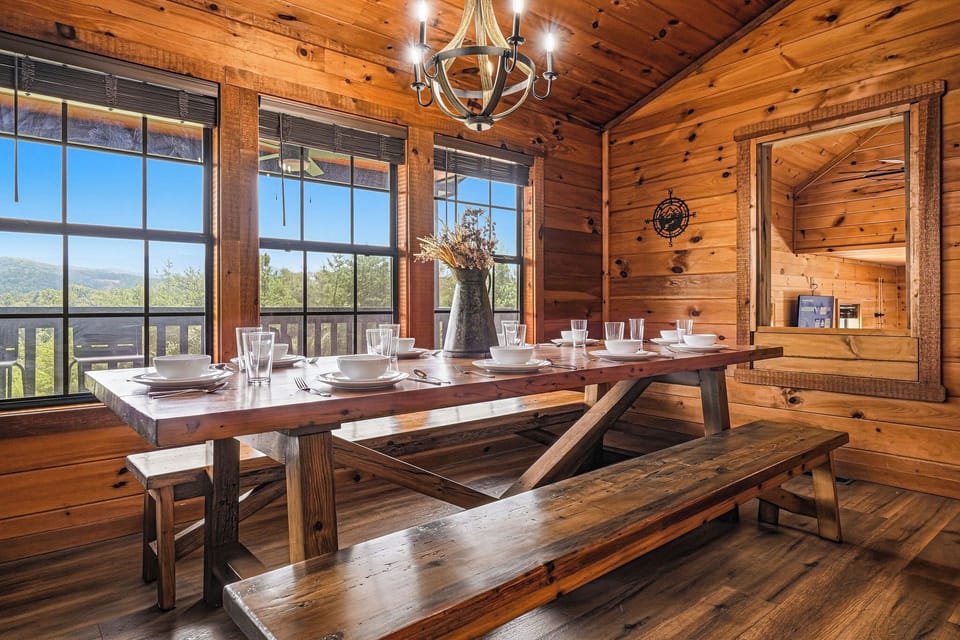 Gather around this handcrafted wooden table for family meals beneath the rustic chandelier, while the mountain view through the windows makes every bite more memorable.