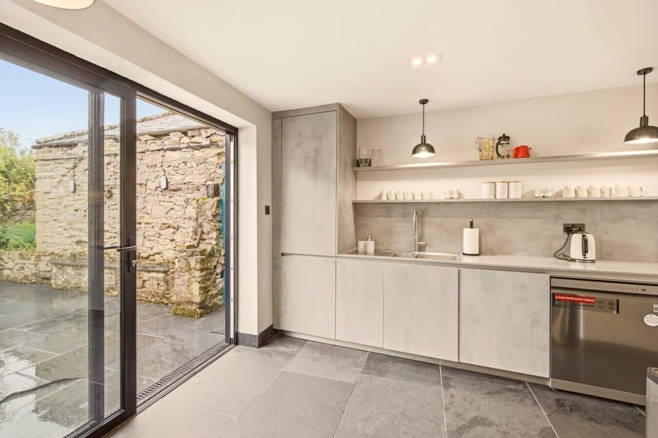 Contemporary kitchen with bi-fold doors opening onto the garden.