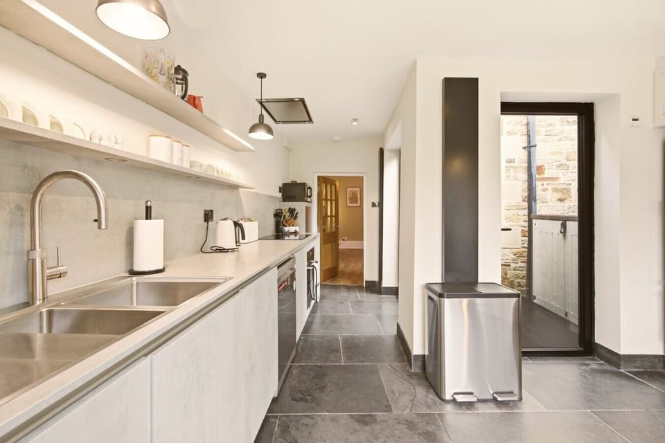 Modern fitted kitchen with garden access and ample preparation space.