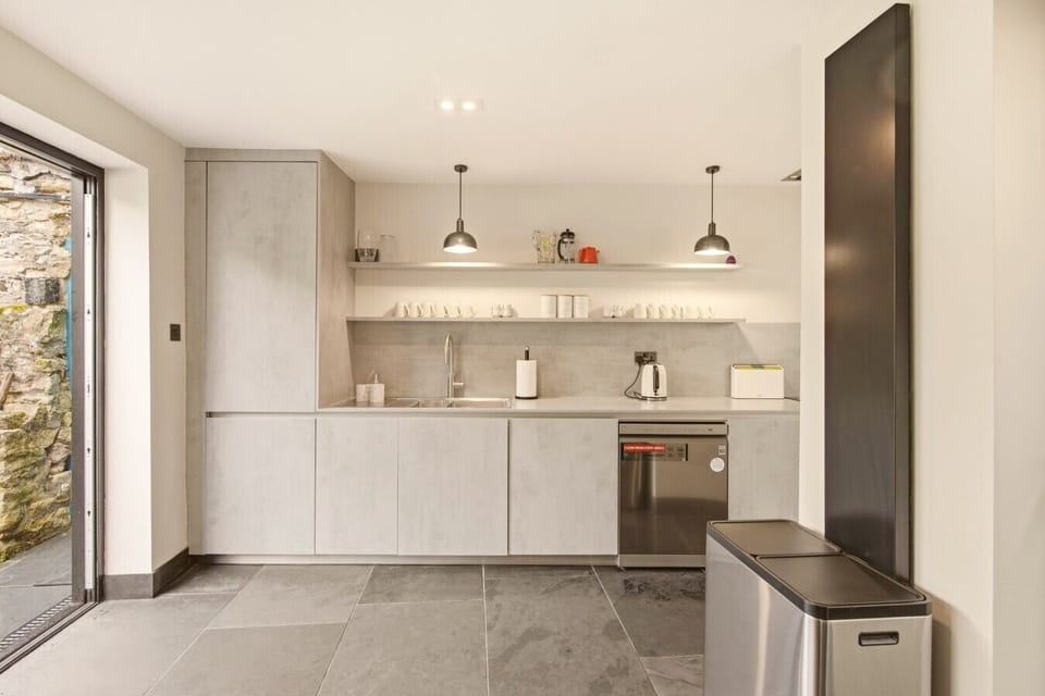 Contemporary fitted kitchen with garden access and integrated appliances.