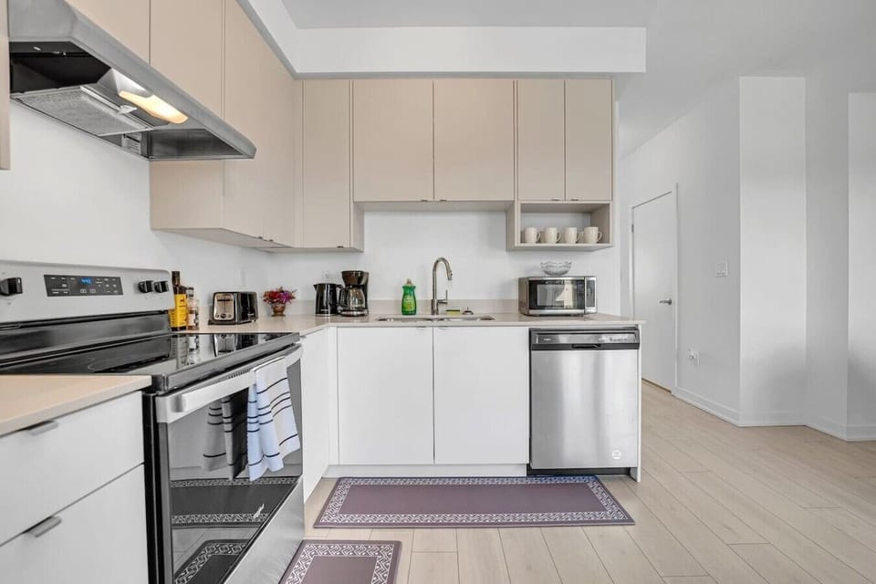 A corner view of the kitchen counter featuring a coffee maker, microwave, and sink next to the stove—ideal for brewing fresh morning coffee or cleaning up after dinner.