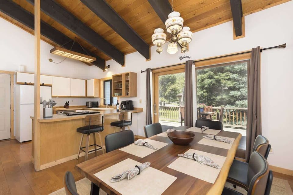 Counter seating for two, Sliding-glass doors provide access to outdoor dining on private deck, Tropical hardwood dining table seats six. 