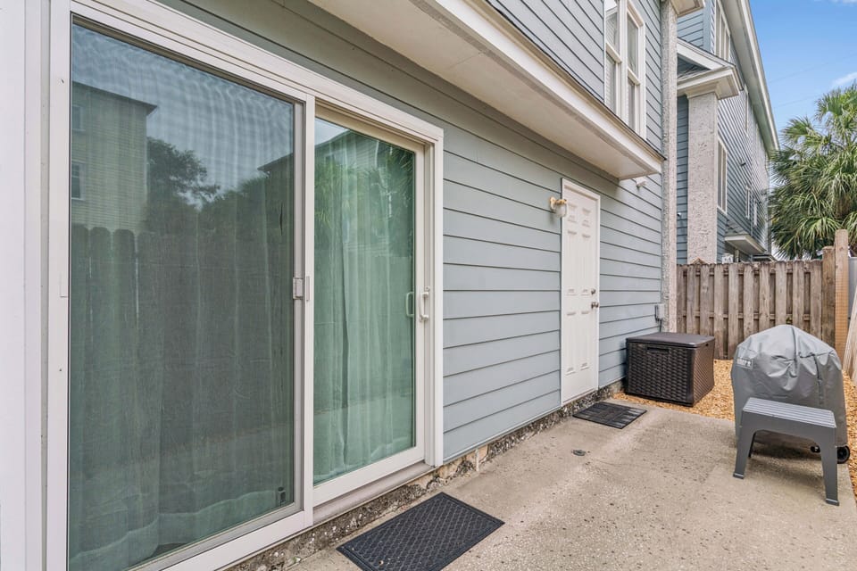 The property's exterior entrance welcomes you with easy outdoor access and convenient amenities like a grill and storage—perfect for your getaway.