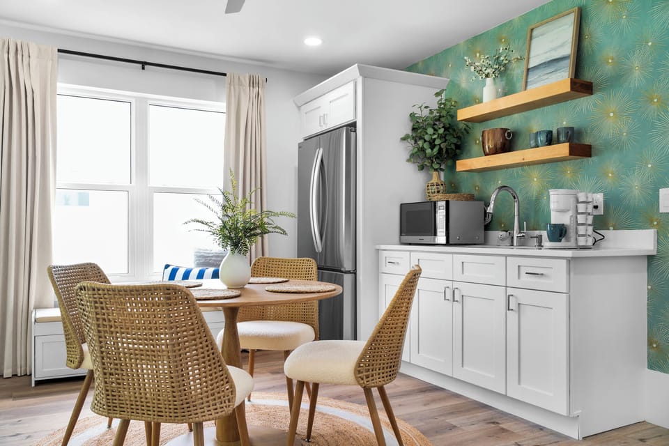 Start your morning right! ☕ Grab a cup from the fully equipped coffee bar, set against a fun teal starburst feature wall and floating oak shelves.