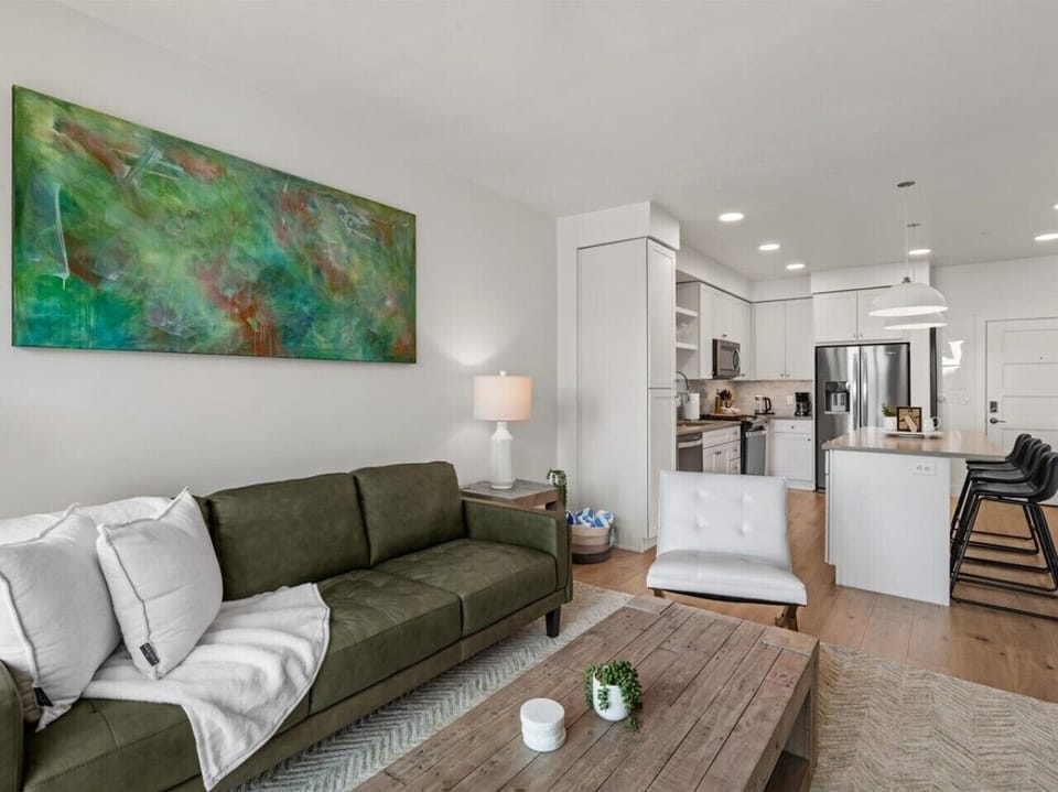 Beautifully designed living room. 75` TV, leather sofa and amazing views of mountains and city skyline.
