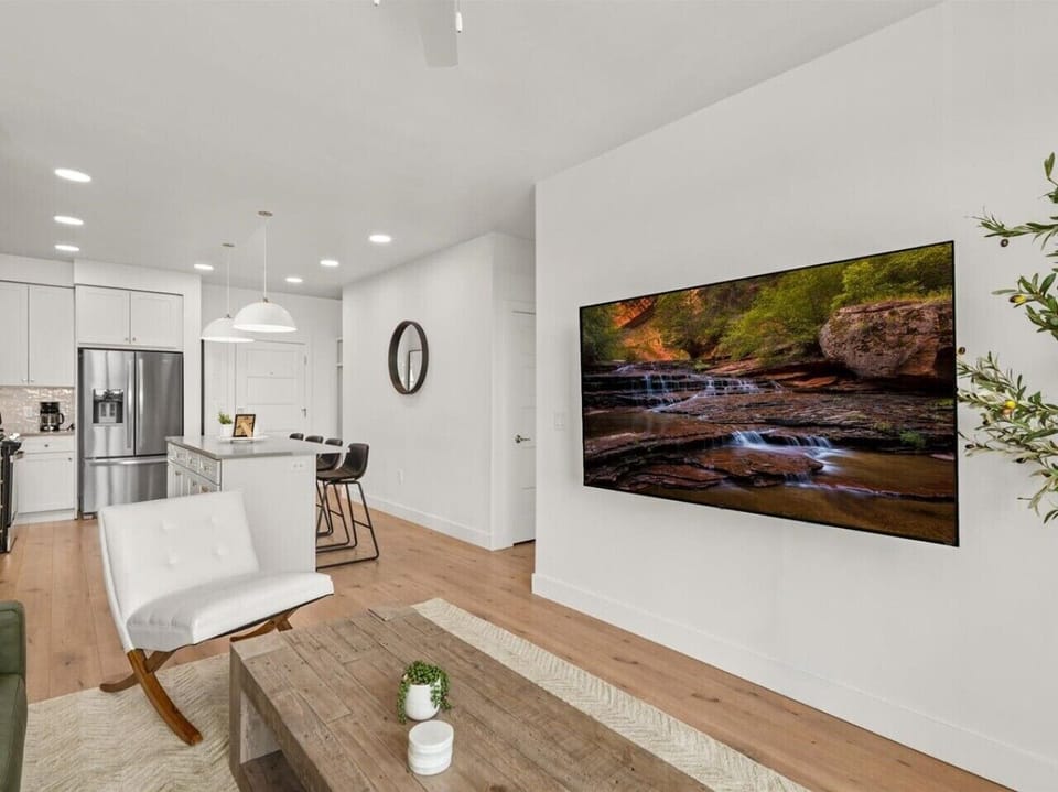 Beautifully designed living room. 75` TV, leather sofa and amazing views of mountains and city skyline.