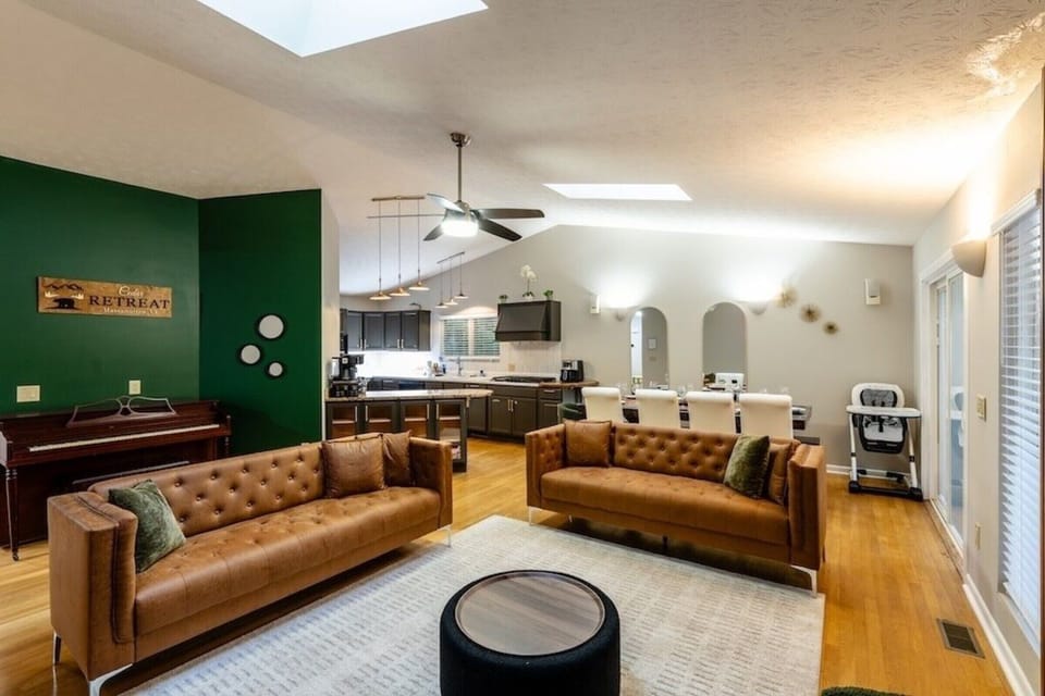 Bright open living space with leather sofas, skylights, and dining area