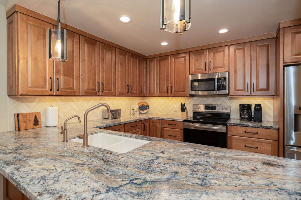 The fully equipped kitchen offers generous counter space and stainless-steel appliances