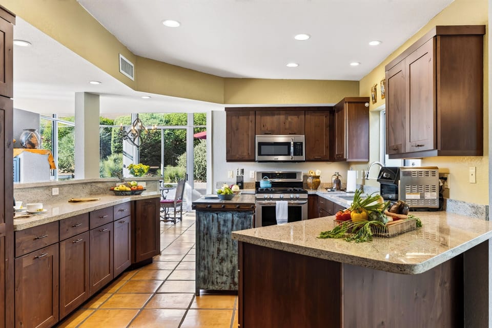 Cook and gather in the well-appointed kitchen, featuring generous counter space, a gas range, and a built-in coffee setup.