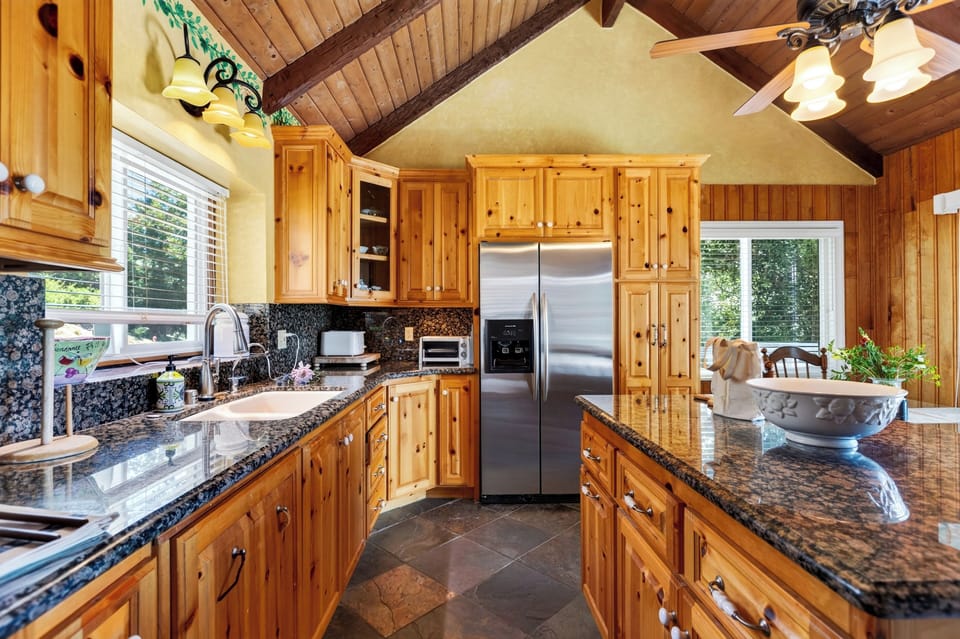 Full kitchen view showing granite countertops and stainless steel appliances.