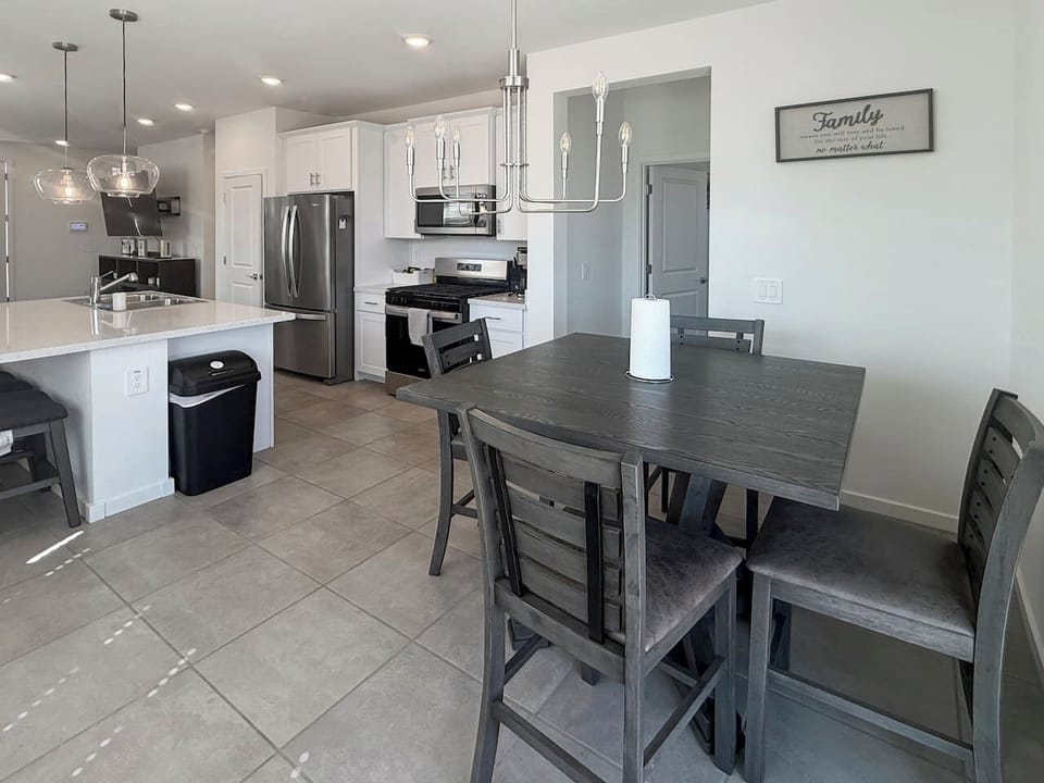 Dining table beside kitchen with four chairs