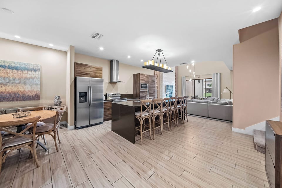 Welcome to this spacious kitchen, where sleek granite countertops and rich wood cabinetry create a warm gathering space. The stylish dining area with a round table is perfect for shared meals, bathed in natural light.