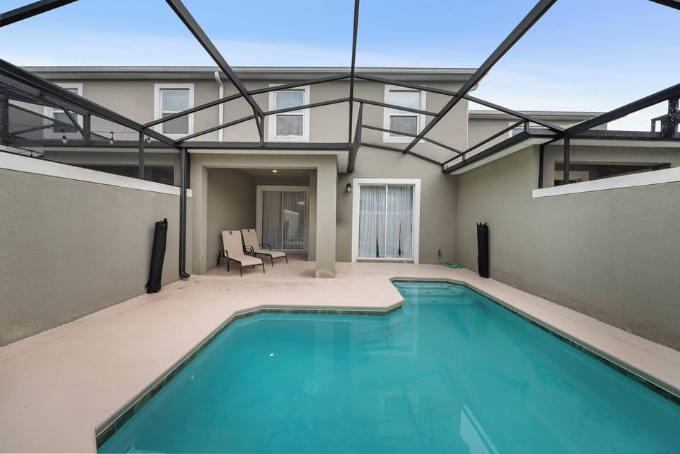 Step into your private oasis with a sparkling pool sheltered by a spacious screened enclosure. Unwind on the comfy lounge chairs in a serene setting, perfect for enhancing your vacation experience.