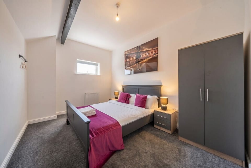 Restful double bedroom with bold pink accents and generous wardrobe storage.