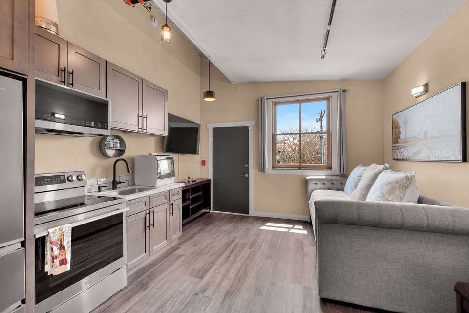 🍳 Enjoy a bright open-concept space with a fully equipped kitchen, comfortable sofa, and dining area—perfect for relaxing and preparing meals.
