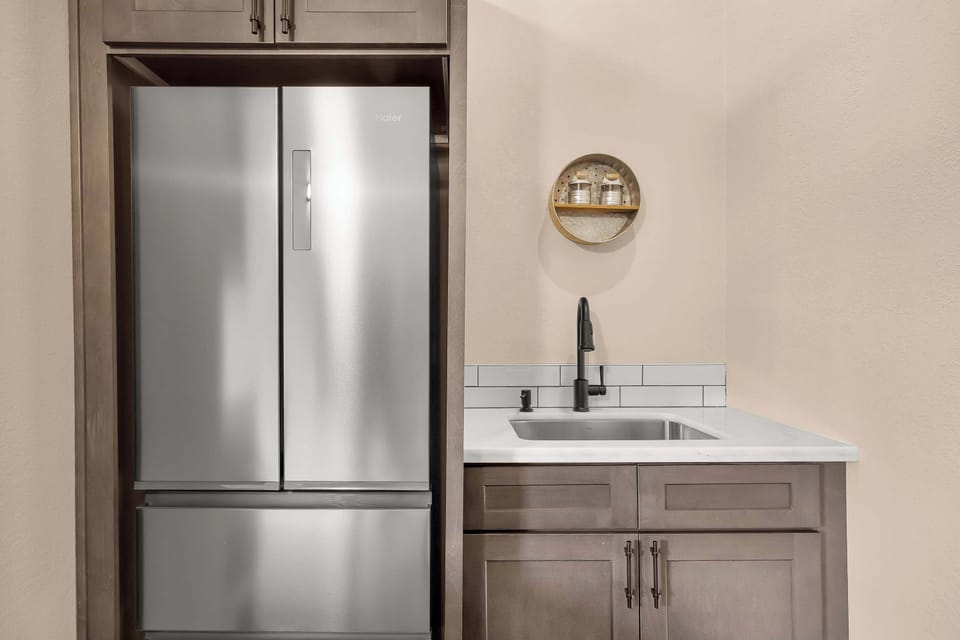 🍽️ A practical kitchen setup with a full-size refrigerator, spacious sink, and ample cabinet storage for your stay.