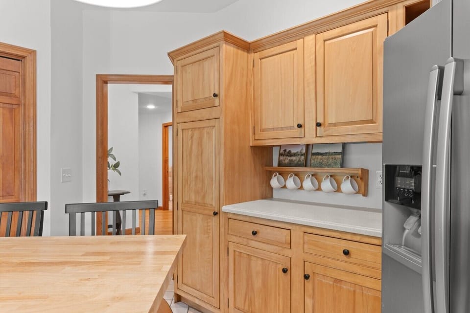 Warm wooden cabinets frame the kitchen, creating a cozy, grounded backdrop for morning coffee and big group meals.