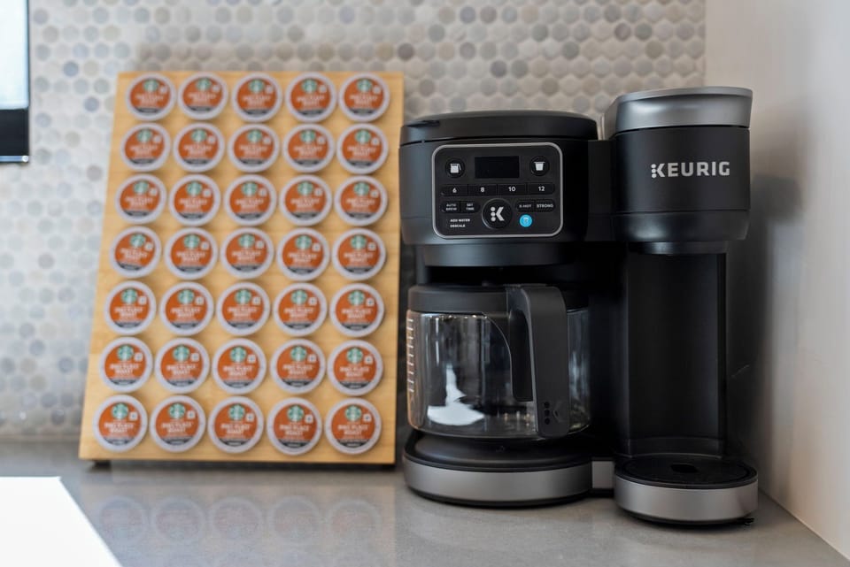 [Kitchen - Main Floor | Convenient coffee station with Keurig brewer and stocked coffee pods]
