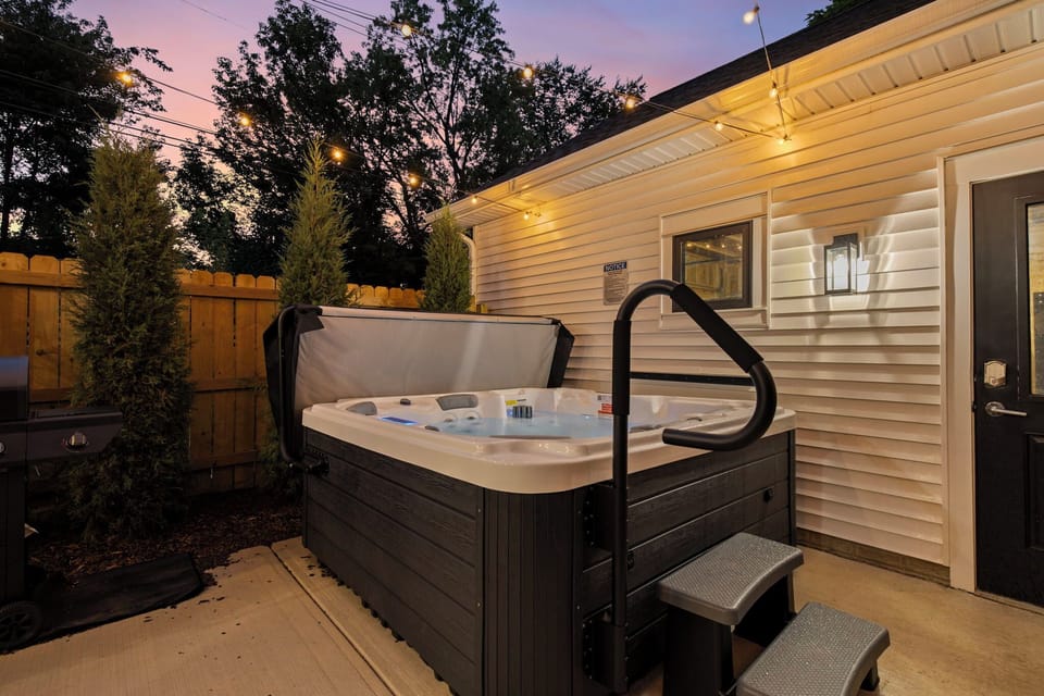 [Private backyard patio | 6-person Hot Tub under string lights for a cozy evening soak]