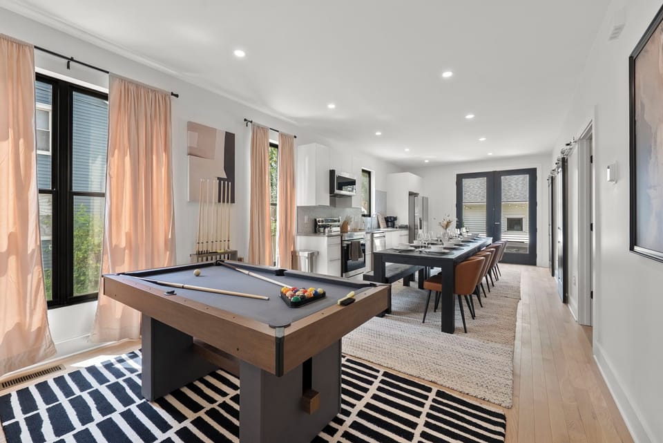 [5.5 ft Pool table behind couch - Main Floor | Bright open concept | Kitchen and 12-seat dining table fits entire family comfortably]