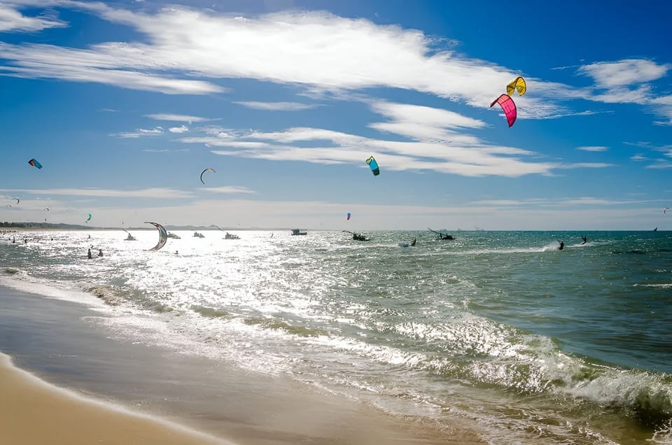 Sunny beachfront with sparkling waves and exciting kitesurfing views