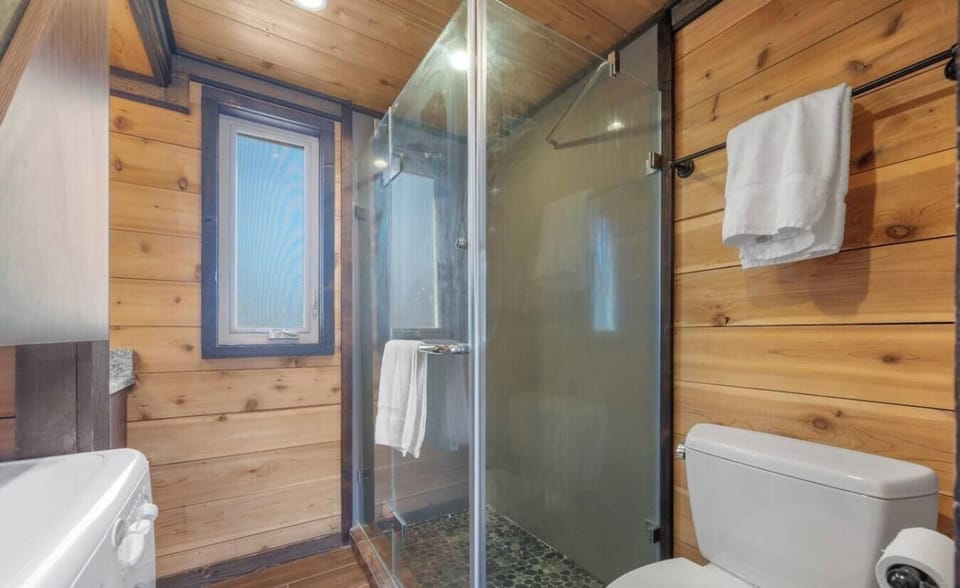Freshen up in the private bathroom featuring a glass-enclosed shower with detailed tile flooring.