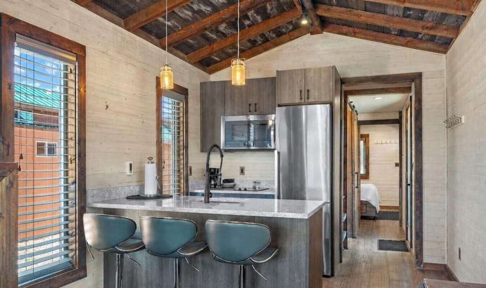 Cook and gather in Cabin 1’s inviting kitchen, featuring a spacious island with seating and a convenient open layout.