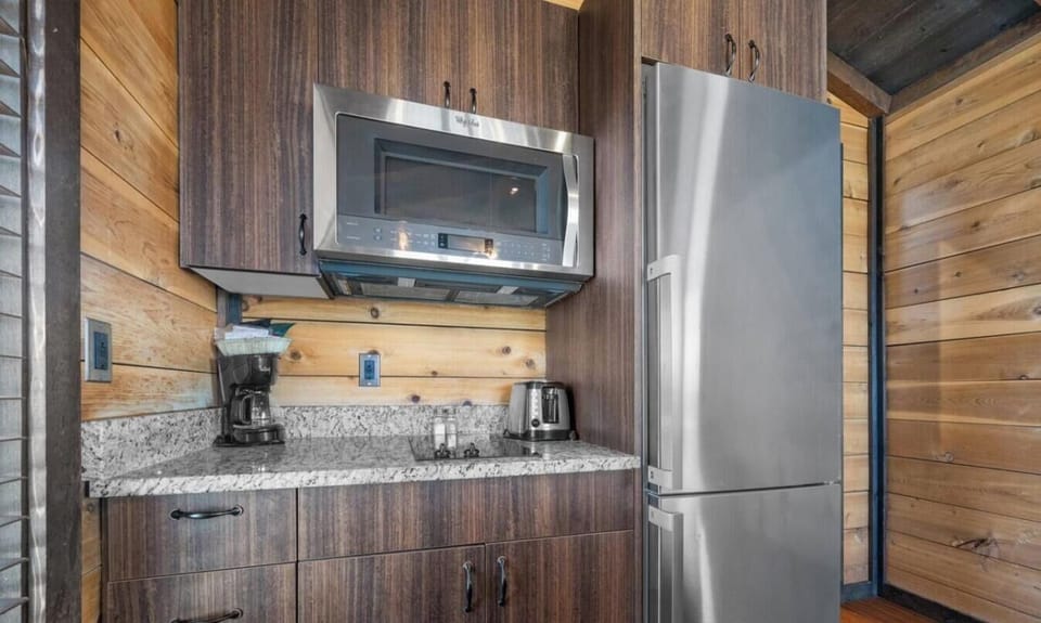 Step into Cabin 2’s kitchen, equipped with stainless steel appliances, a microwave, coffee maker, and toaster for easy meal preparation.