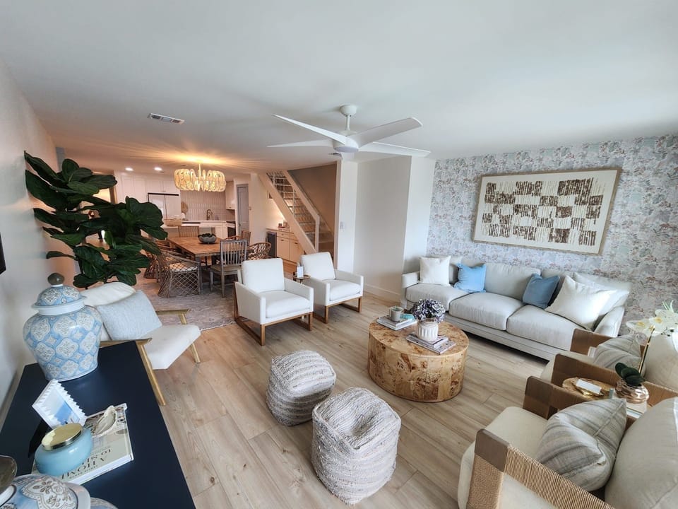 Bright open living space with stylish seating, dining area, and coastal charm.