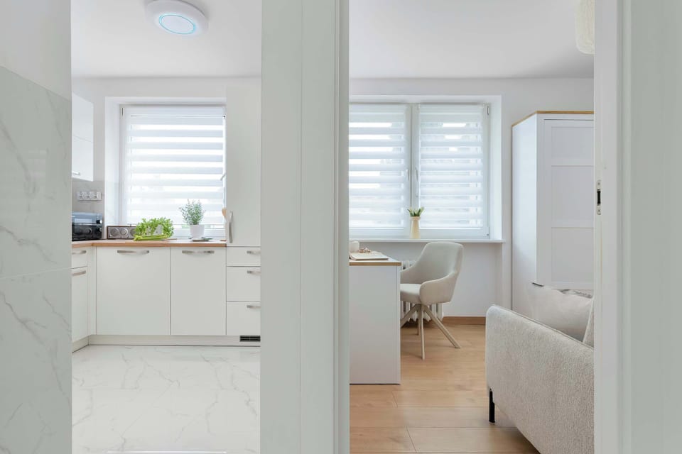 A hallway connects the kitchen and bedroom, creating an open and practical flow through the apartment. Bright finishes enhance the sense of space.