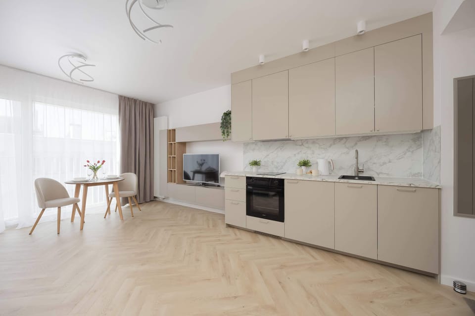 A spacious view of the modern kitchenette and dining area within the open-plan apartment.
