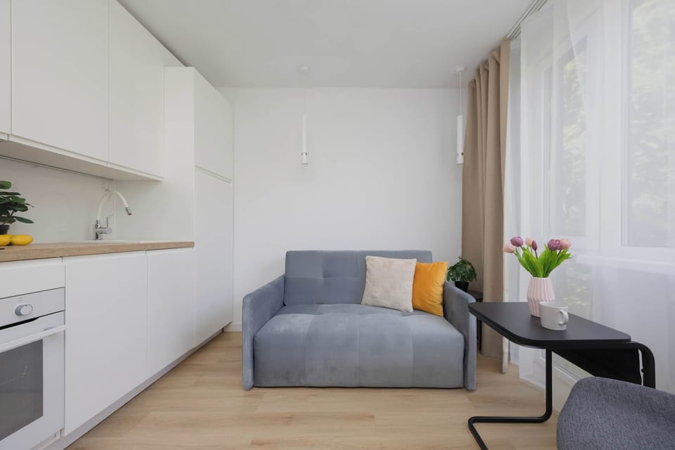 Cozy seating area with a sofa, small table, and large windows providing plenty of natural light.