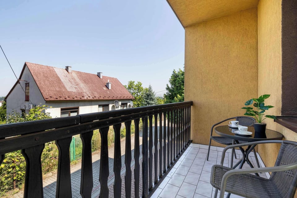Balcony with outdoor seating, a small table, and views of the neighborhood.