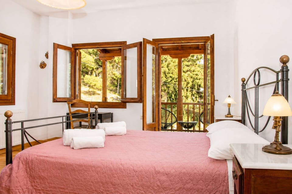 Double bed with access to the balcony and views of the surrounding greenery.